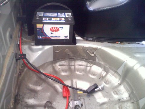 1993 Ford Probe - AAA battery installed in the trunk of a car, with visible wiring and battery tray.
