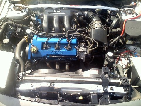 1993 Ford Probe - Engine bay view of a blue Ford engine, a silver intake manifold and strut bar.