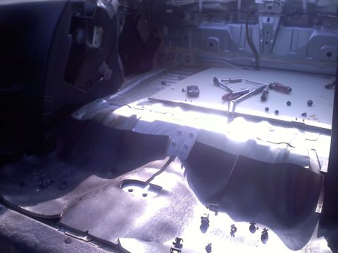 1993 Ford Probe - The interior of a car is shown with the seats removed and various tools laid out on the floor.