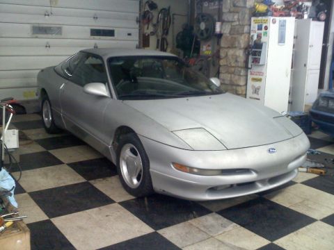 1993 Ford Probe - A silver 1993 Ford Probe GT is parked inside a garage, with tools and storage cabinets visible in the background.