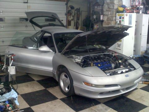 1993 Ford Probe - Silver 1993 Ford Probe GT coupe with hood and trunk open, parked in a garage with tools and equipment visible.