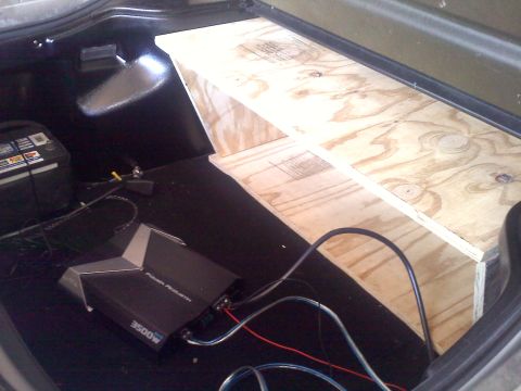 1993 Ford Probe - Custom wood subwoofer box and amplifier installed in a vehicle's trunk.