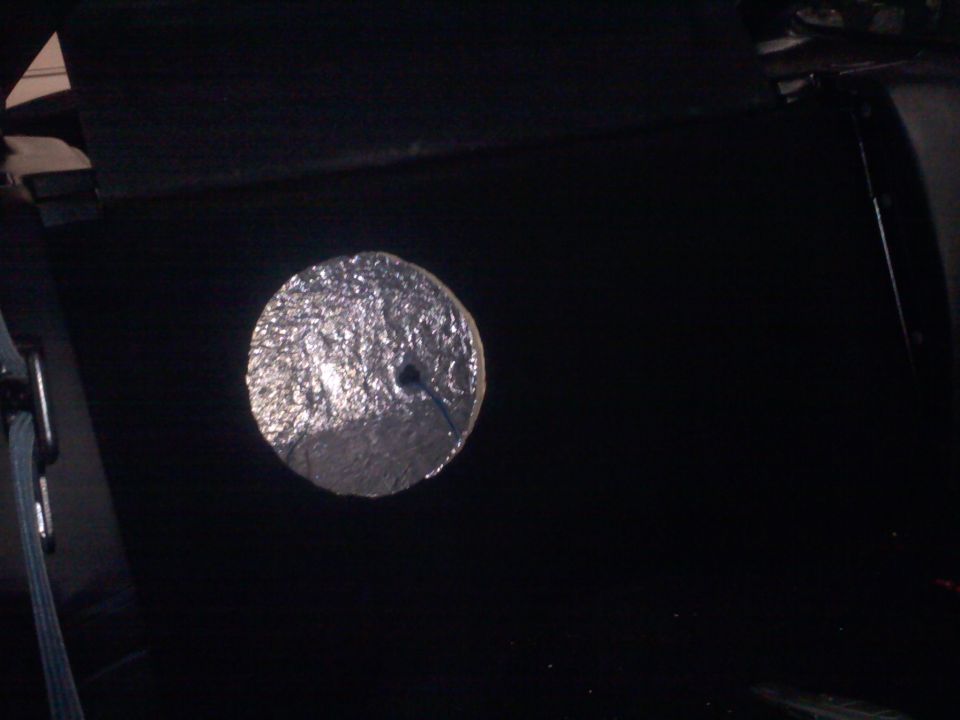 Circular metal object with a hole in the center, possibly a hubcap or wheel cover