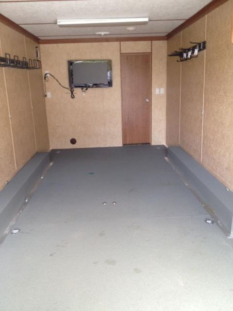 1967 Ford Mustang - The interior of a trailer is shown, a mounted television and hooks on the walls.