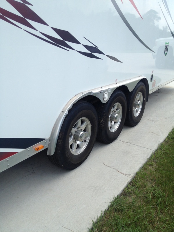 White trailer with triple axles and silver star wheels, seen from the side