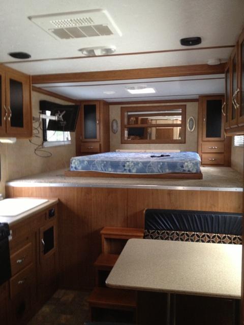 1967 Ford Mustang - Interior view of a recreational vehicle, a raised sleeping area, dinette, and kitchen amenities.