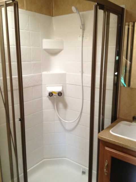 1967 Ford Mustang - Interior view of a recreational vehicle's bathroom, showing a shower stall and a sink area.