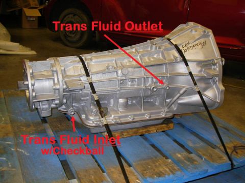 1990 Ford Bronco - A transmission part is shown with labels indicating fluid inlet and outlet ports.