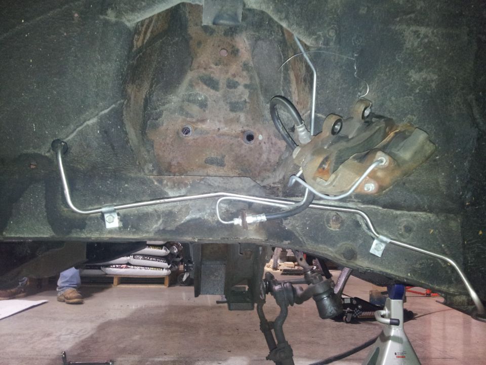 Car frame with brake caliper and brake lines visible