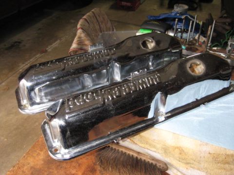 1963 Ford Galaxie - Chrome valve covers with raised lettering are shown on a workbench, possibly for a classic car engine.