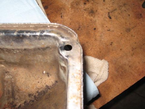 1963 Ford Galaxie - This is a close-up view of an oil pan, showing a mounting hole and some signs of wear and tear.