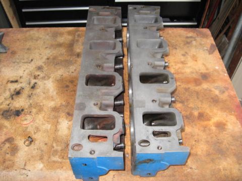 1963 Ford Galaxie - Pair of engine cylinder heads shown on a wooden surface.