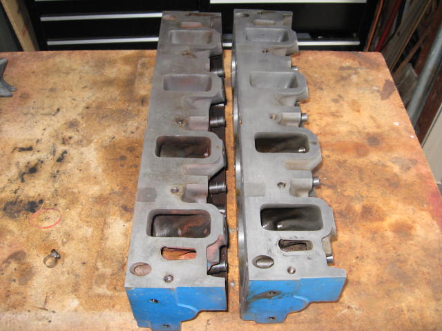Two engine cylinder heads on a workbench