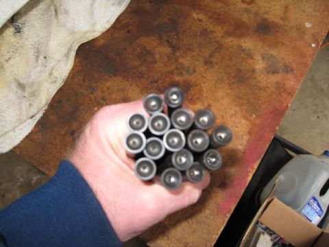 1963 Ford Galaxie - A hand holds a group of valve lifters, likely for engine repair or rebuild.