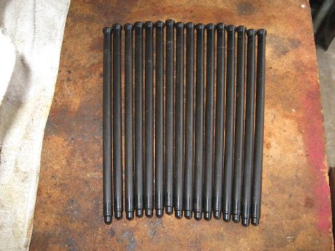 1963 Ford Galaxie - A collection of engine pushrods are neatly arranged on a textured surface, possibly for sale or repair.