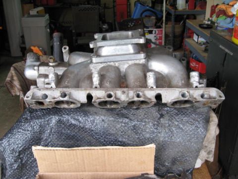 1963 Ford Galaxie - Aluminum intake manifold with visible numbers, likely for a V8 engine, shown in a garage setting.