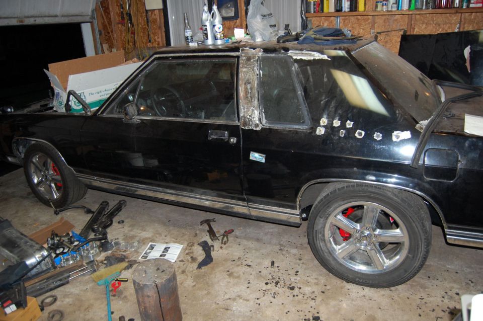 1985 Mercury Grand Marquis side view, black sedan with custom wheels and red brake calipers
