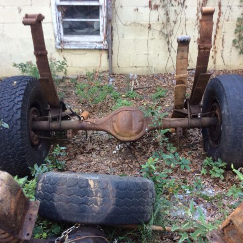 1979 Ford Bronco - This is a rear axle assembly with leaf springs and tires, likely for an older truck or off-road vehicle.