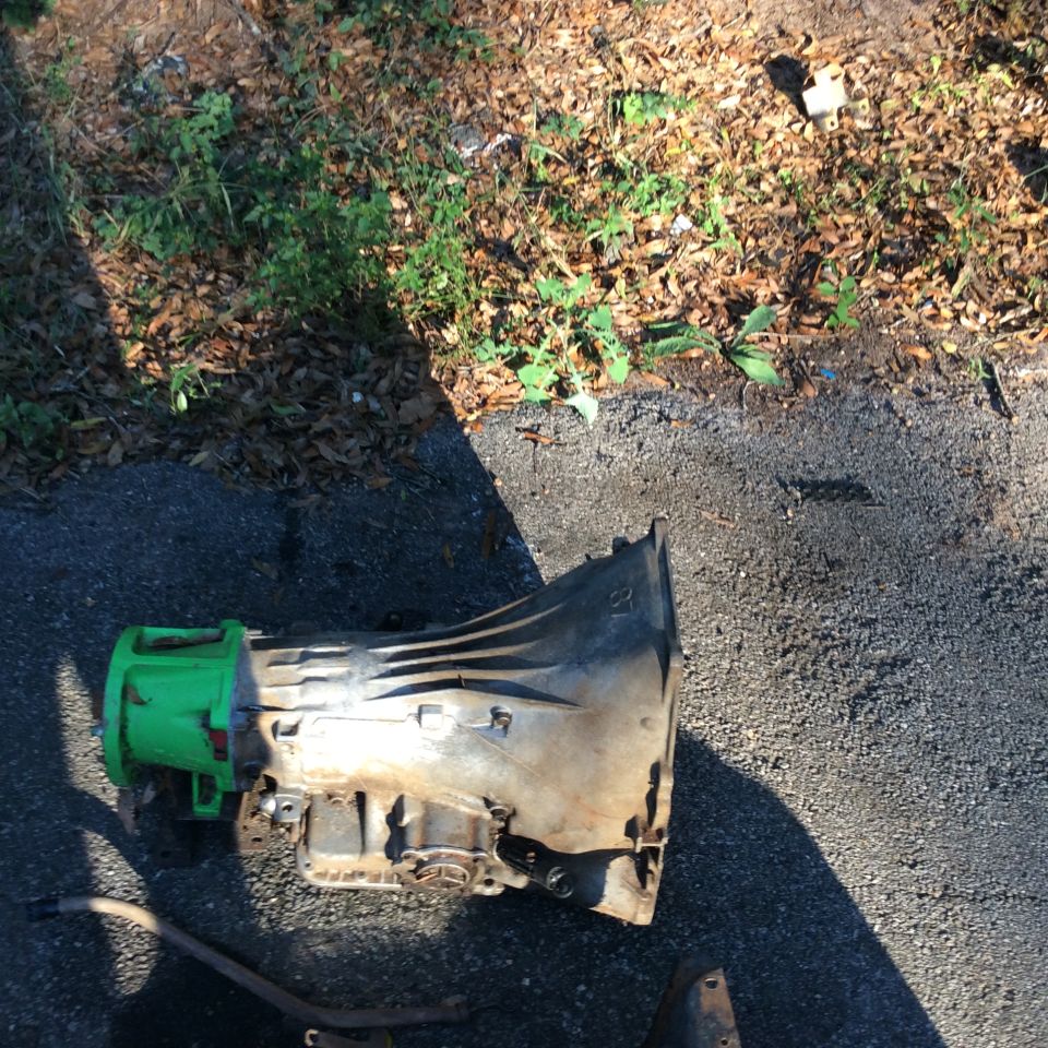 Green and silver transmission part on asphalt