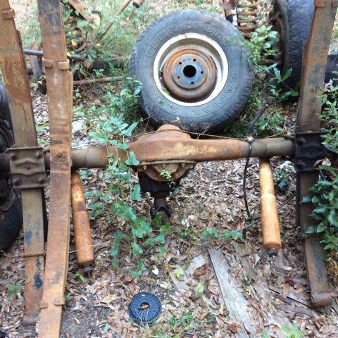 1979 Ford Bronco - Rusty rear axle assembly with leaf springs and shock absorbers, likely from an older truck or SUV.