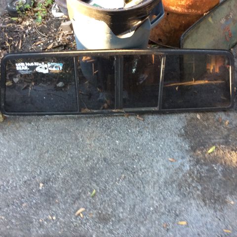 1979 Ford Bronco - Rear window assembly with stickers on glass, possibly from a 1979 Ford Bronco.
