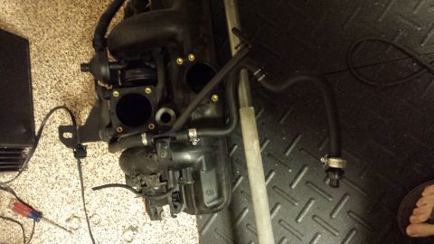 2002 BMW 3 Series - A disassembled engine intake manifold with various hoses and connectors is shown on a textured floor.