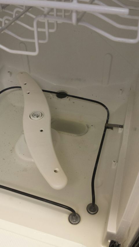 1989 Ford Bronco - Interior view of a dishwasher, showing the spray arm and basin.