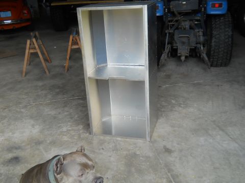 1992 Ford Bronco - An aluminum cabinet sits in a garage next to a blue tractor, with a dog in the foreground.