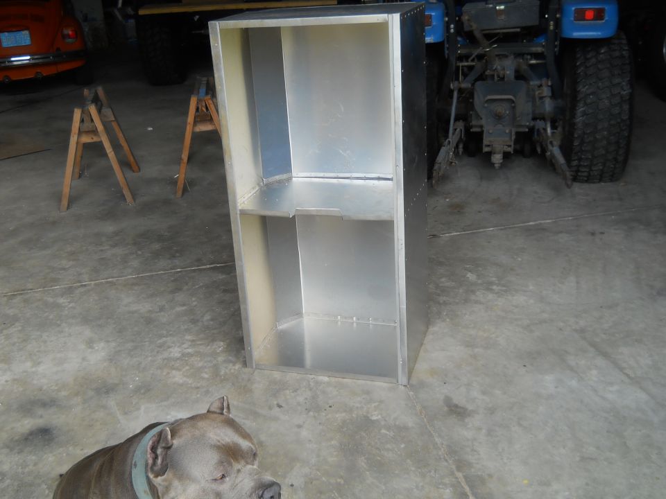 Aluminum cabinet in garage with blue tractor and dog