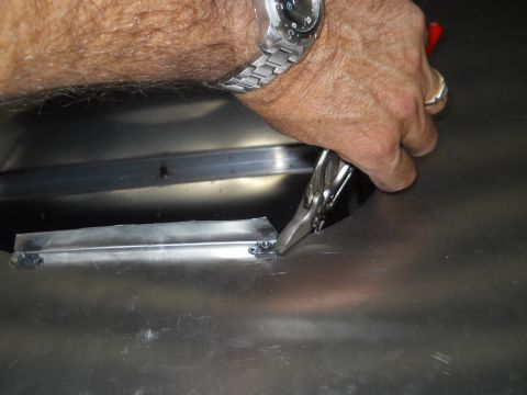 1992 Ford Bronco - A person is working on a metal panel, using tools to adjust its shape.