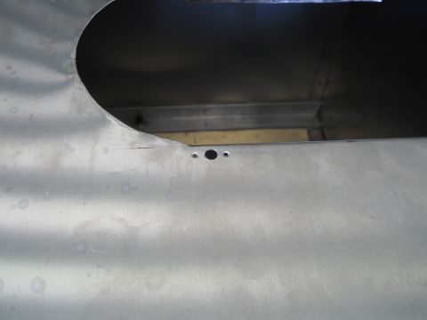 1992 Ford Bronco - Close-up of an unpainted metal panel with a large cutout and two small holes, possibly from a vehicle's interior or body.