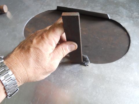 1992 Ford Bronco - A hand holds a metal bracket over a circular cutout on a metal surface, with a Supermotors.net logo visible.