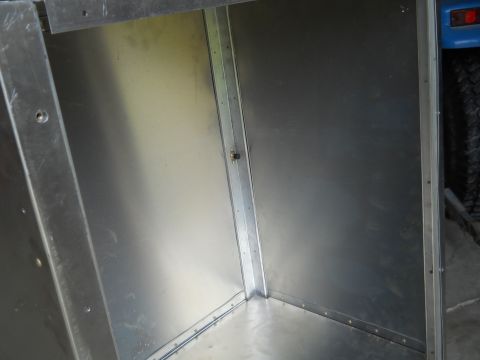 1992 Ford Bronco - The interior of a metal box structure, possibly a cargo area, with a portion of a blue vehicle visible.
