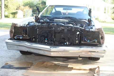 1976 Ford Ranchero - Front view of a white 1972 Ford Ranchero with its hood open, revealing a disassembled engine bay and a prominent chrome bumper.