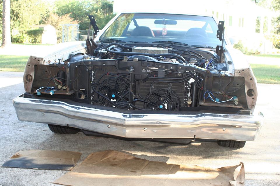 White 1972 Ford Ranchero front end with hood open, showing disassembled engine bay and chrome bumper