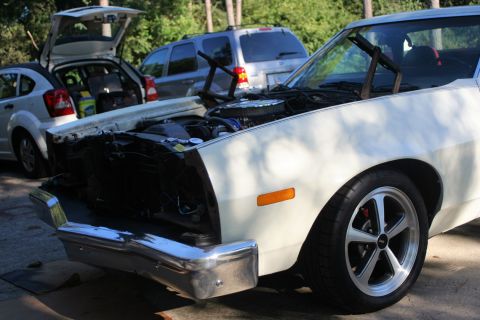 1976 Ford Ranchero - Front view of a 1976 Ford Ranchero with its hood open, parked outdoors with other vehicles.