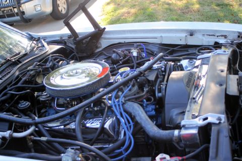 1976 Ford Ranchero - The engine compartment is open, revealing the motor and various hoses and wires.