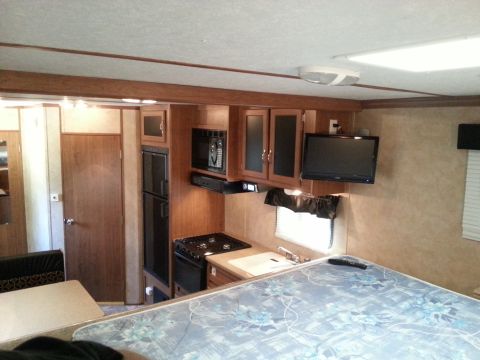 1967 Ford Mustang - The interior of a recreational vehicle shows a compact kitchen area and a bed.