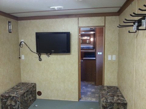 1967 Ford Mustang - Trailer interior with TV, storage, and visible sleeping area through an open doorway.