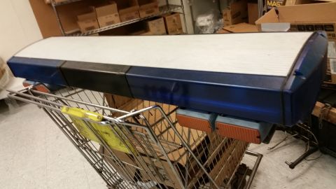 2001 Ford Crown Victoria - A light bar is placed on a shopping cart in what appears to be a storage area.
