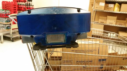 2001 Ford Crown Victoria - A blue light bar is seen mounted on a shopping cart in front of shelves of boxes.