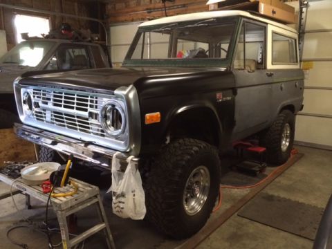 1988 Suzuki Samurai - Ford Bronco undergoing work in a garage, parked next to another vehicle.