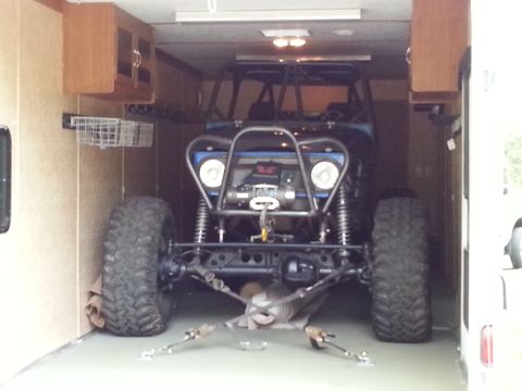 1967 Ford Mustang - This heavily modified off-road vehicle is being transported inside a trailer, a prominent winch and oversized tires.