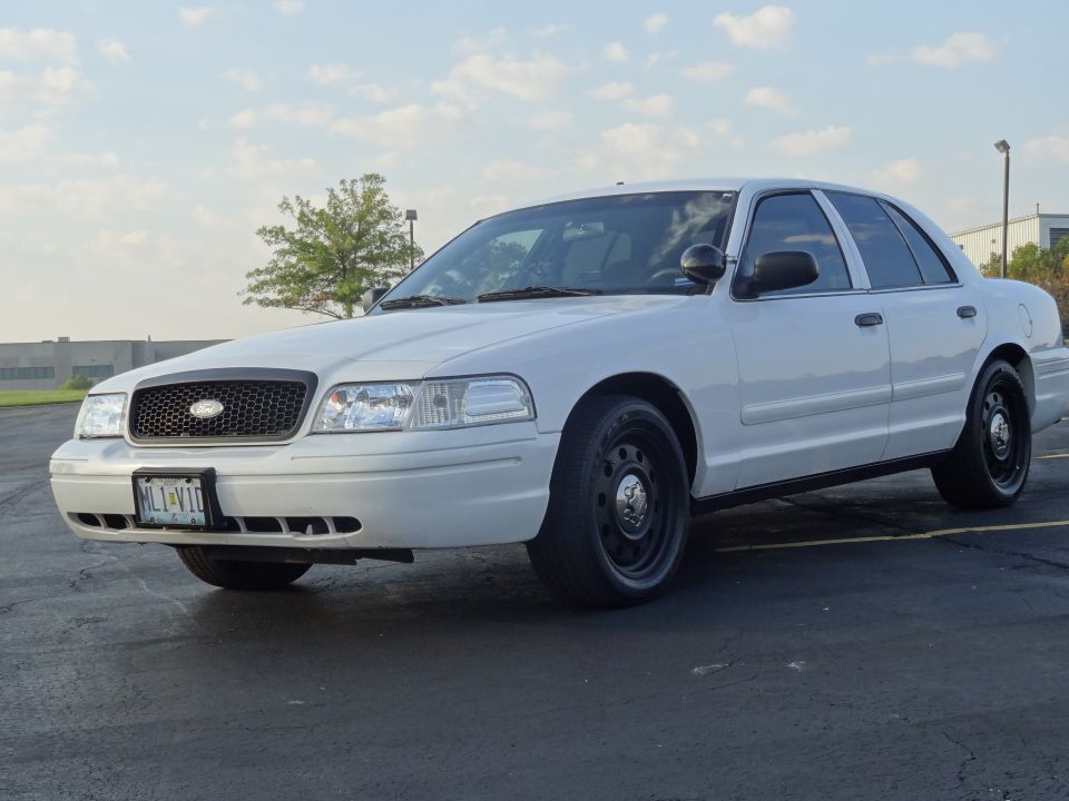 White 2007 Ford Crown Victoria sedan with black grille and steel wheels, parked on asphalt