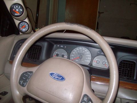 2004 Ford Crown Victoria - Interior view of a Ford Crown Victoria, showing the dashboard, steering wheel, and aftermarket gauges.