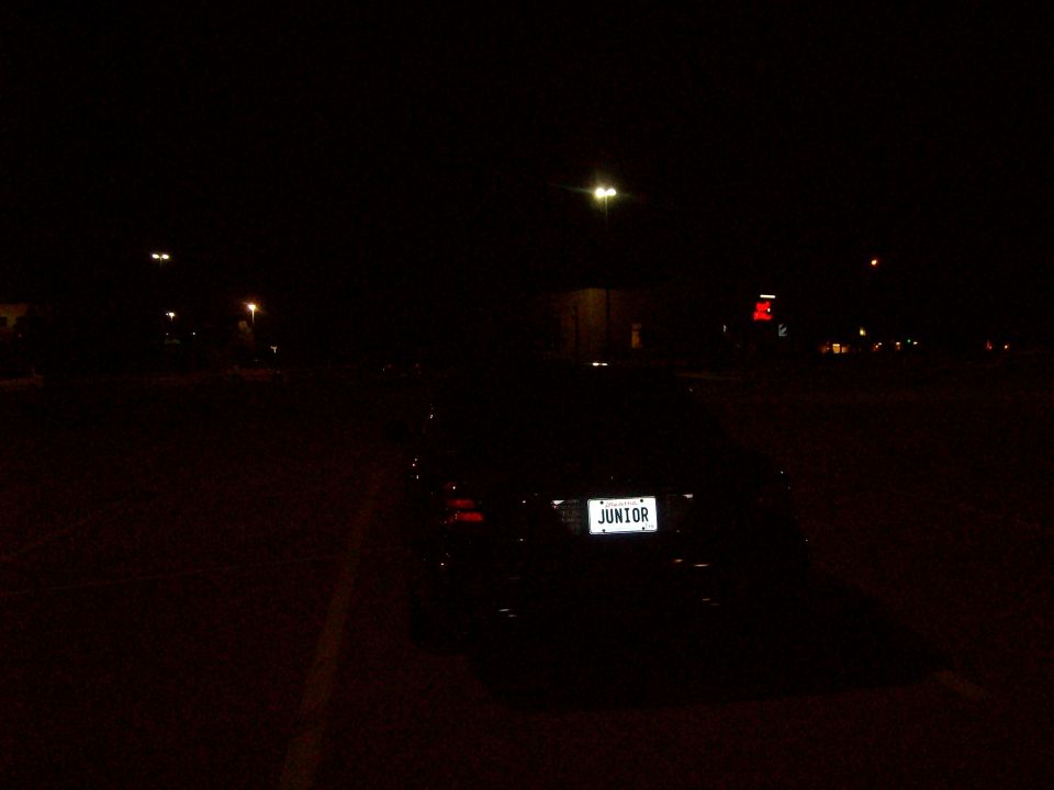 Car with license plate reading JUNIOR at night