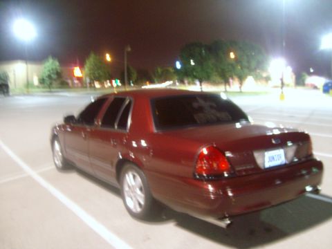 2004 Ford Crown Victoria - Rear view of a red 2004 Ford Crown Victoria parked in a lot at night.