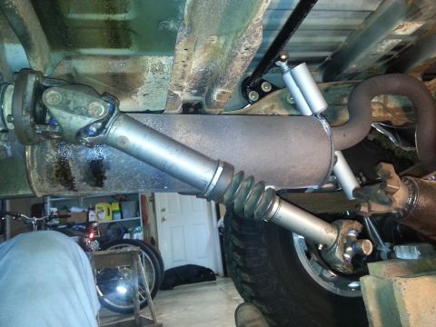 1995 Ford Bronco - Underside view of a vehicle's driveshaft and exhaust system, highlighting the U-joint and muffler components.