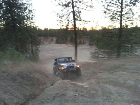 2005 Jeep Wrangler - A 2005 Jeep Wrangler navigates a challenging off-road course, kicking up dust as it goes.