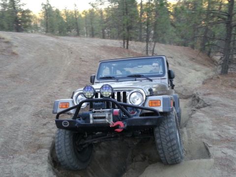 2005 Jeep Wrangler - Jeep Wrangler Rubicon navigating an off-road trail with steep inclines and loose dirt.